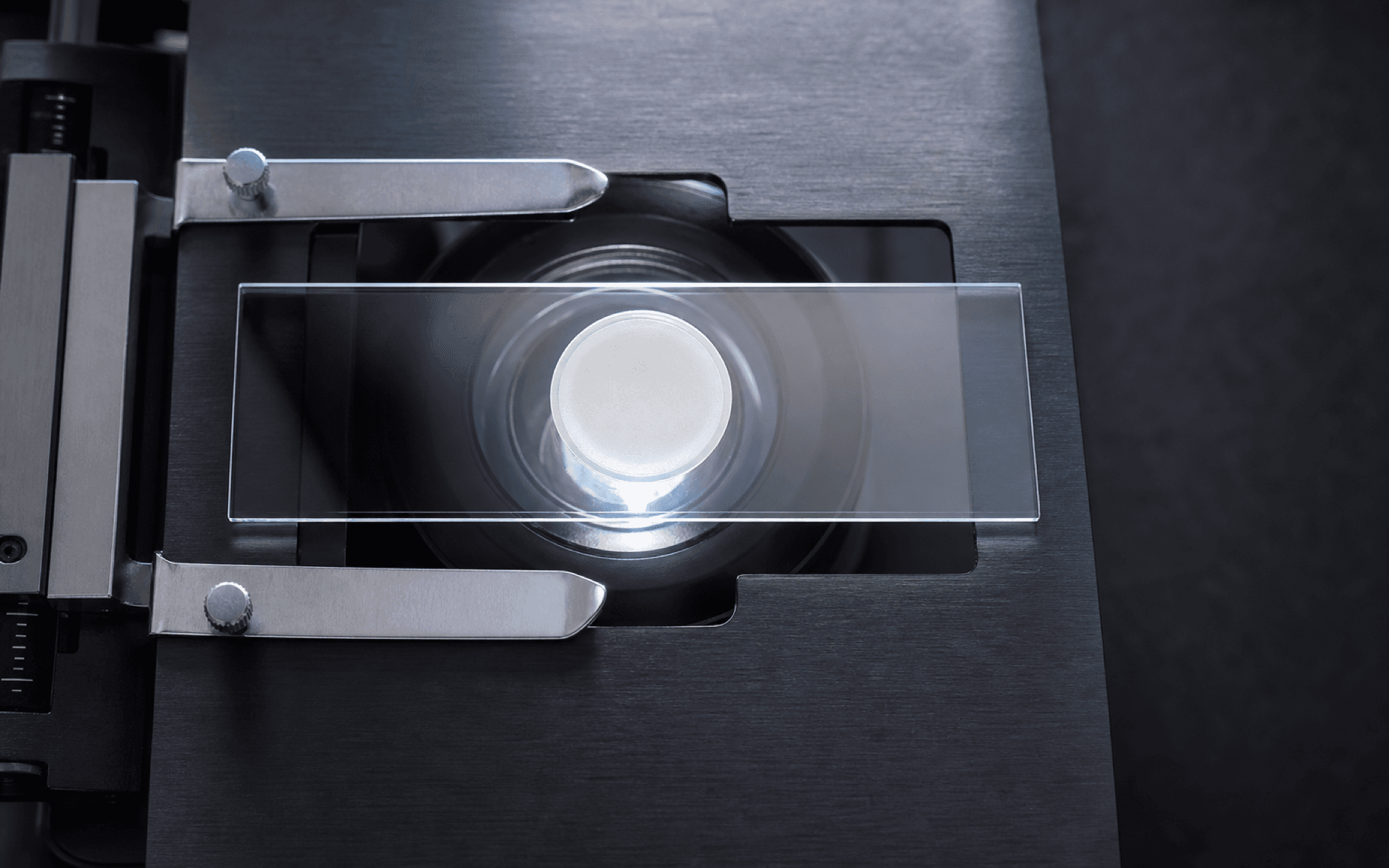 Principle illustration: an overhead microscope stage with a milky uncleared circular membrane and no targets visible before clearing
